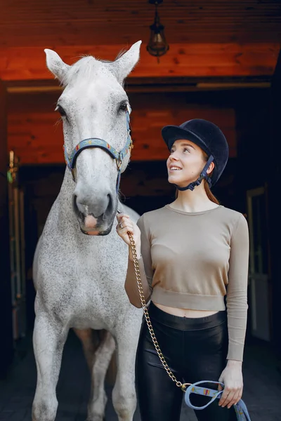 Hermosa mujer de pie con un caballo — Foto de Stock