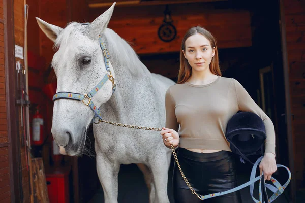 Mulher bonita de pé com um cavalo — Fotografia de Stock