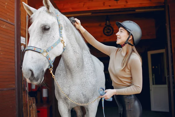 Güzel bir kadın atıyla ayakta duruyor