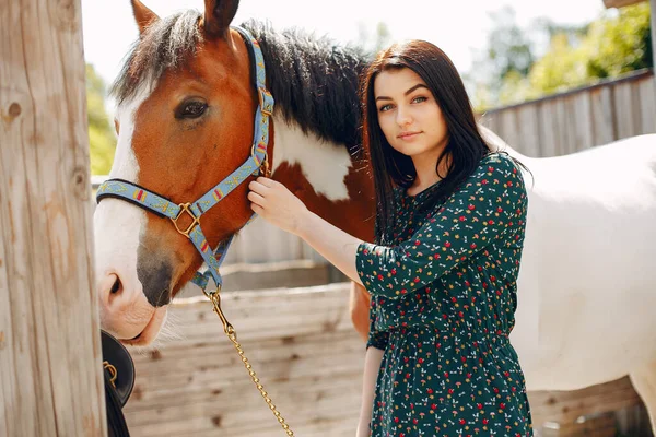 Schöne Frau steht mit einem Pferd — Stockfoto