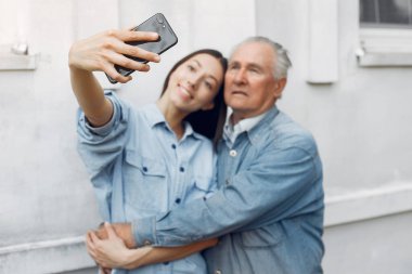Kız, dedesine telefon kullanmayı öğretiyor.