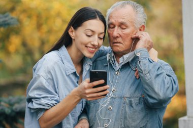 Kız, dedesine telefon kullanmayı öğretiyor.