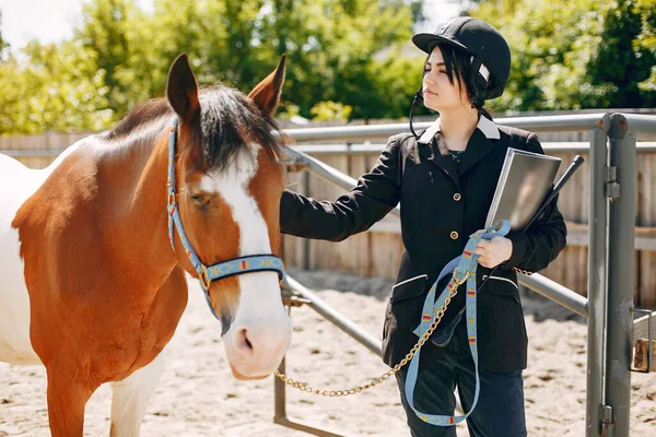 Schöne Frau steht mit einem Pferd — Stockfoto