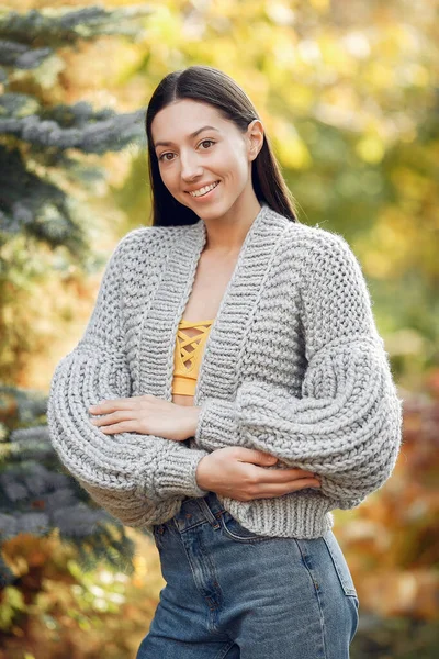 Dívka v pletené svetr stojící na stromech pozadí — Stock fotografie