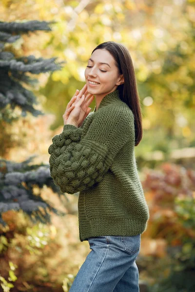 Mädchen im Strickpullover steht auf Bäumen — Stockfoto