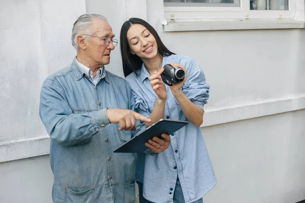 Mädchen bringt ihrem Großvater bei, wie man ein Tablet benutzt — Stockfoto