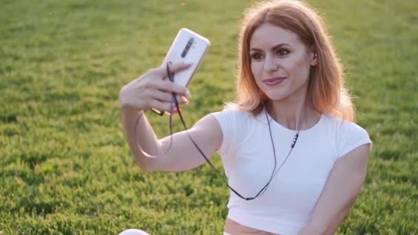 Blond gorgeous woman is taking selfie on the green background — Stock Video