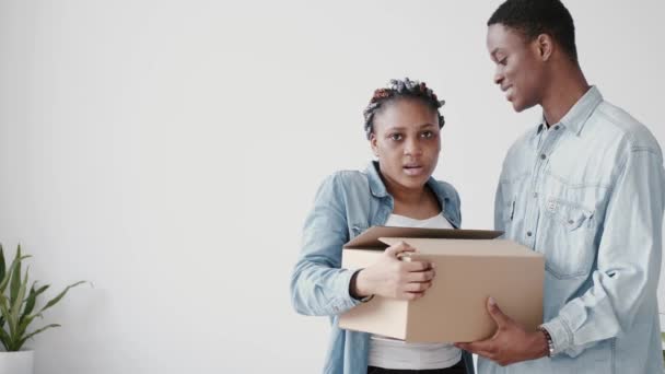Młoda para Afroamerykanów pakuje pudła z rzeczami. — Wideo stockowe