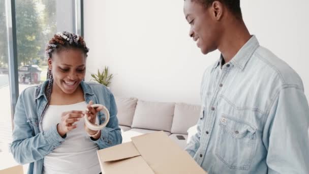 Afrikai-amerikai barát és barátnő pakolnak egy dobozt. — Stock videók