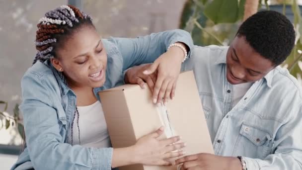 African- American boyfriend and girlfriend are packing a box — Stock Video