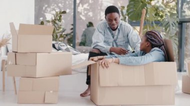 Afro-Amerikalı çift apartmanda kutularla oynuyorlar.