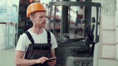 Üniformalı bir adam depoda bekliyor.