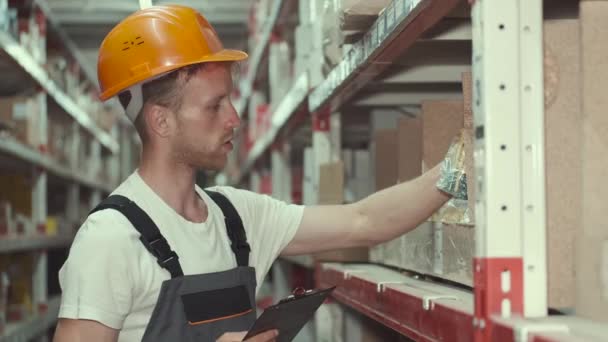 Рабочий в шлеме проверяет материалы на заводе — стоковое видео