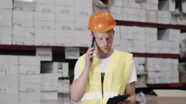 Miğferli fabrika mühendisi üretimi kontrol ediyor.