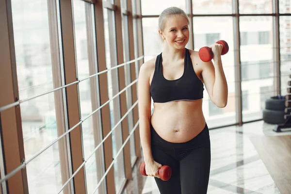 Pregnant woman plays sports with dambbels — Stock Photo, Image