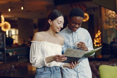 Uluslararası insanlar bir kafede durup kahve içiyorlar.