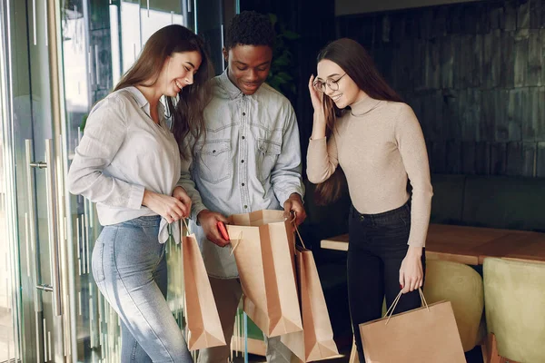 Uluslararası insanlar bir kafede dikilip kameraya bakıyorlar.
