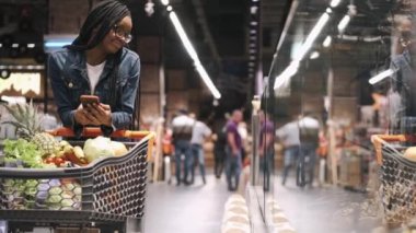 Markette telefonu ve tramvayı olan Afrikalı bir kız.