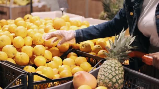 Nera giovane donna sta scegliendo arance in un supermercato — Video Stock