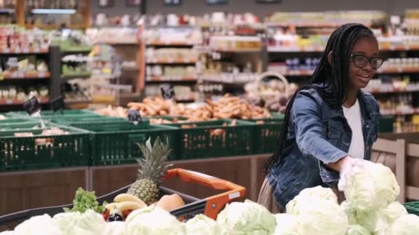 Maskeli Afro-Amerikalı genç kadın süpermarketten ürün seçiyor. — Stok video