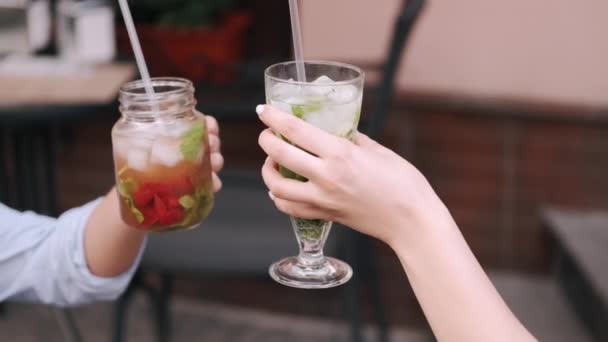 Closeup of two female hands holding cocktails with ice — Stock Video