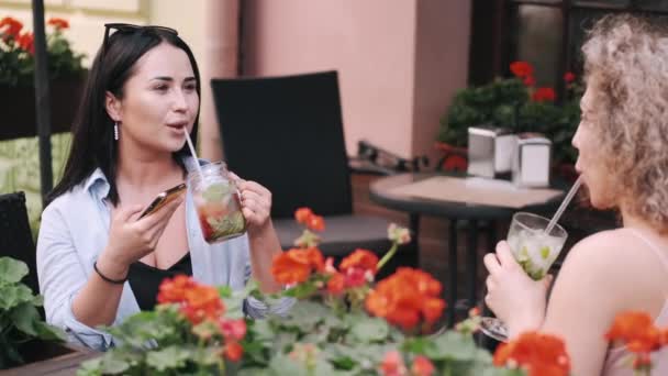 Dvě krásné dámy popíjejí studené koktejly v kavárně — Stock video