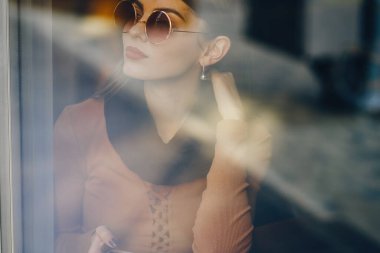 Esmer kız restoranda telefon kullanıyor.