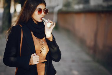 Şık bir kız e-sigara içiyor.