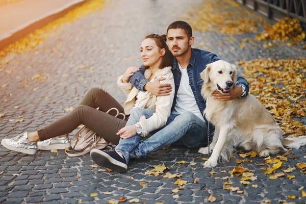 在一个阳光明媚的秋日，一对夫妇在遛狗 — 图库照片