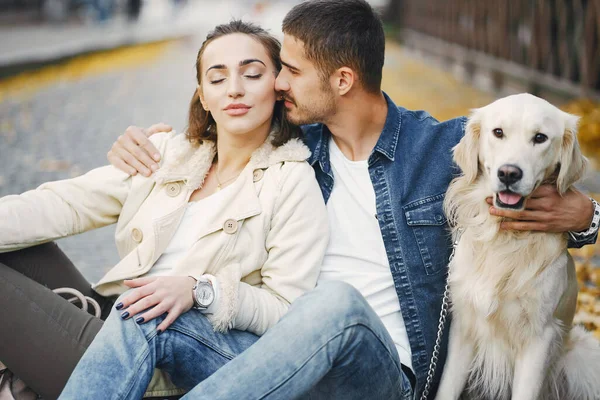 Casal andando seu cão em um dia ensolarado de outono — Fotografia de Stock