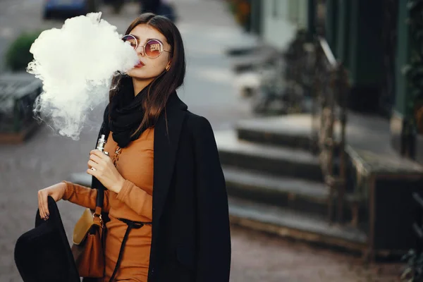 スタイリッシュな女の子は電子タバコを吸う — ストック写真