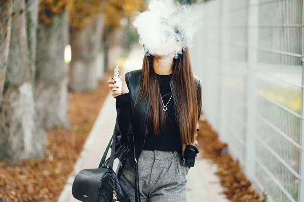Şık bir kız e-sigara içiyor.
