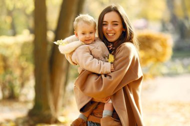 Sonbahar parkında şirin ve şık bir aile.