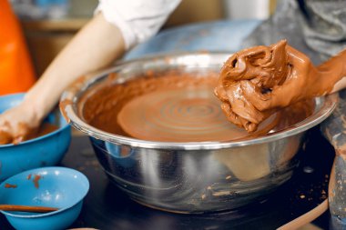 Çömlek makinesinde kilden vazo yapan bir kız.