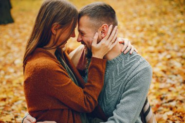 Güzel bir çift sonbahar parkında vakit geçirir.