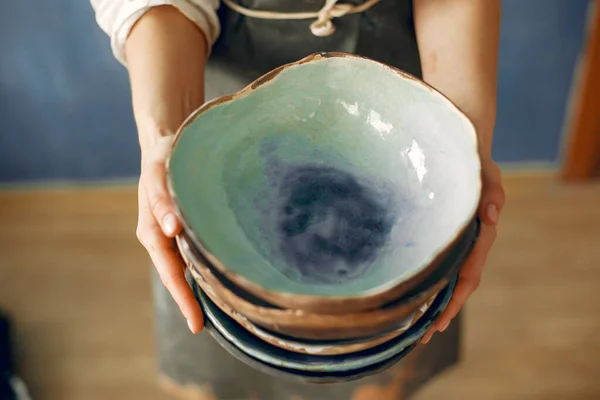 Eine junge Frau hält eine Keramikschale in den Händen — Stockfoto