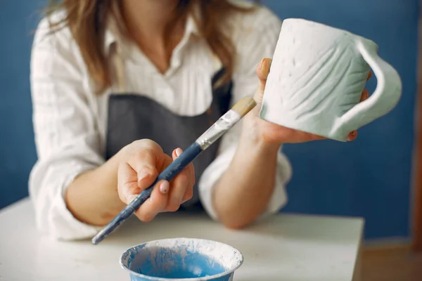 Una joven mujer pintando platos en una cerámica — Foto de Stock