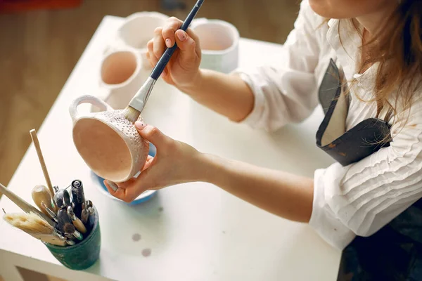 Mladá žena, která maluje nádobí v keramice — Stock fotografie