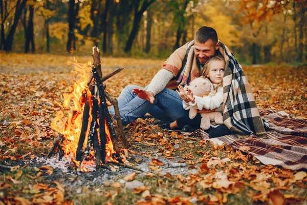 Sonbahar parkında oynayan sevimli bir aile.