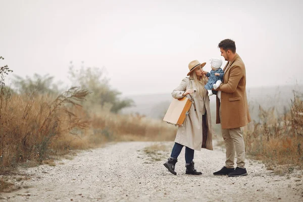 Stijlvolle familie wandelen op een herfstveld — Stockfoto