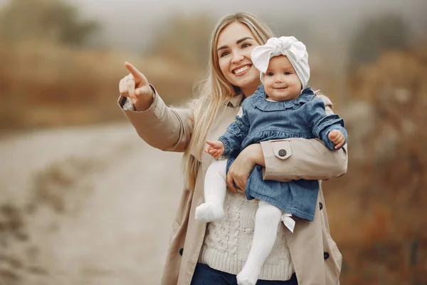 Мама з донькою бавиться на осінньому полі. — стокове фото