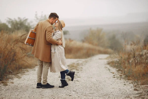 Beautiful couple spend time in a autumn field — Stock Photo, Image