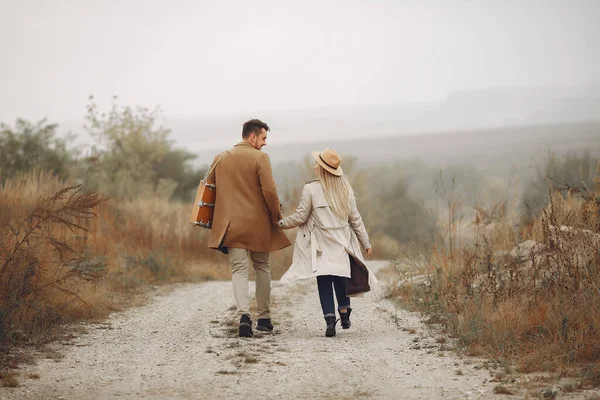 Beautiful couple spend time in a autumn field — Stock Photo, Image