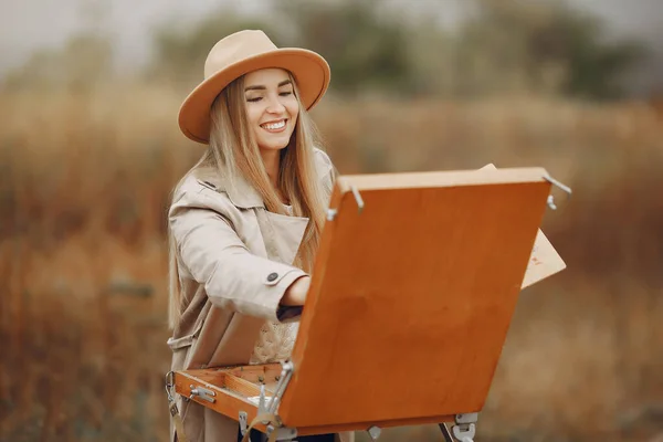 Donna in una pittura cappotto marrone in un campo — Foto Stock