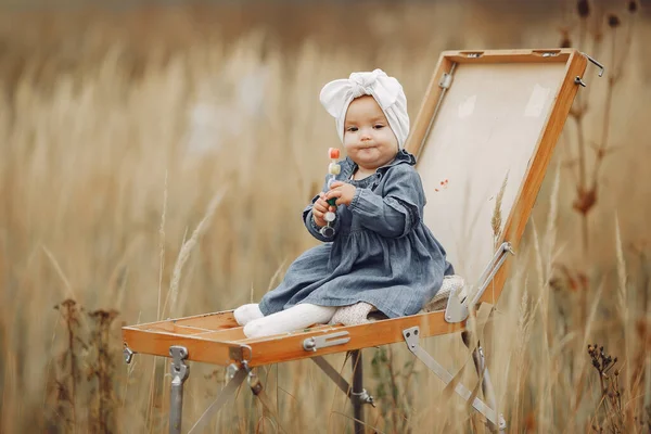 Cute little girl malarstwo w polu jesień — Zdjęcie stockowe