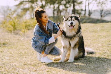 Köpeğiyle bahar tarlasında şık bir kız.
