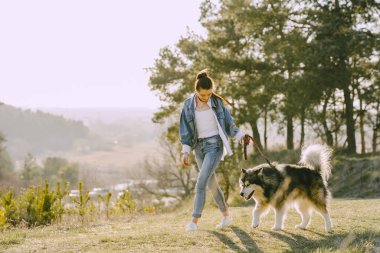 Köpeğiyle bahar tarlasında şık bir kız.