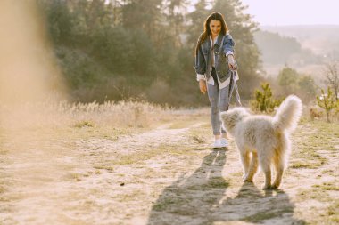 Köpeğiyle bahar tarlasında şık bir kız.