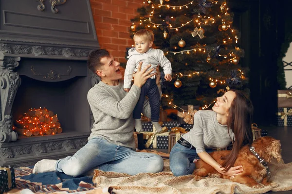Family with cute dog at home near christmas tree