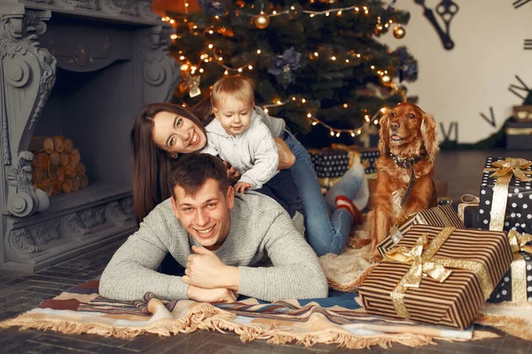 Familia con lindo perro en casa cerca del árbol de Navidad — Foto de Stock